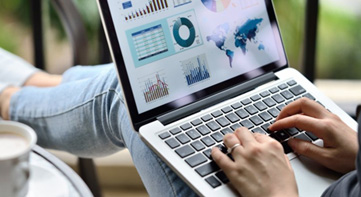 A woman working on a laptop with hands on the keyboard